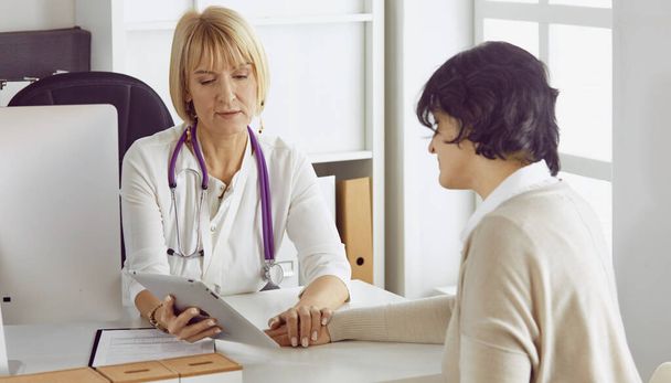 Arzt mit Laptop und schwangere Frau in Arztpraxis - Foto, Bild