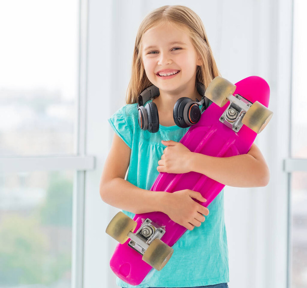Smiling little girl with penny board - Photo, Image