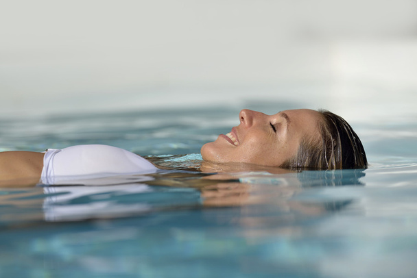 Woman relaxing in swimming pool - Foto, Bild