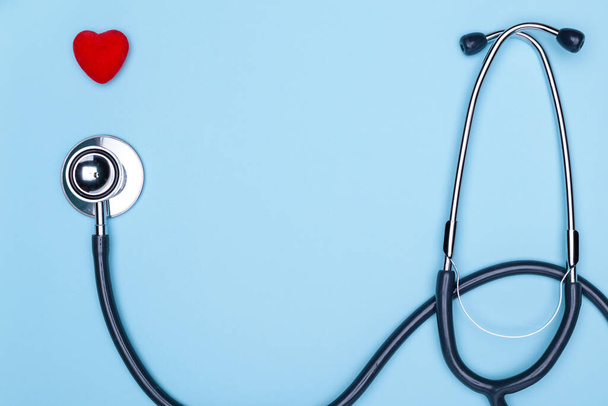 Herz und Statoskop Nahaufnahme auf blauem Hintergrund, Draufsicht. Globales Gesundheitskonzept.Statoskop stilvoller Arzt mit Herz auf blauem Hintergrund. - Foto, Bild