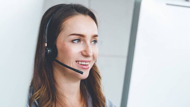 Business people wearing headset working in office to support remote customer or colleague. Call center, telemarketing, customer support agent provide service on telephone video conference call. - 写真・画像