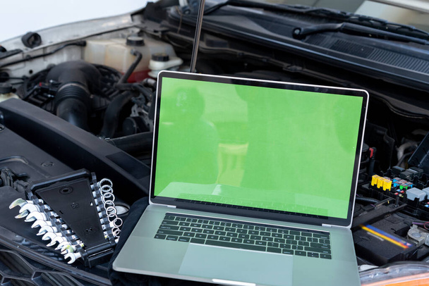Laptop computer on car hood for engine diagnostic. Car garage repair service concept. - Fotoğraf, Görsel