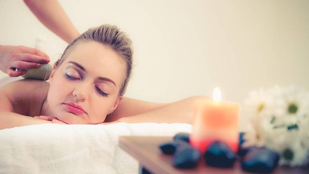 Terapeuta de massagem detém uma compressa herbal para fazer tratamento para a mulher deitada na cama de spa em um resort de spa de luxo. Conceito de bem-estar, alívio do estresse e rejuvenescimento. - Foto, Imagem