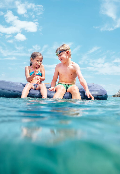 Sister and brother, have fun when swim on inflatable mattress in the sea. Careless childhood time - Foto, Imagem