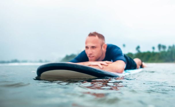 Resting surfer man on the board - Φωτογραφία, εικόνα