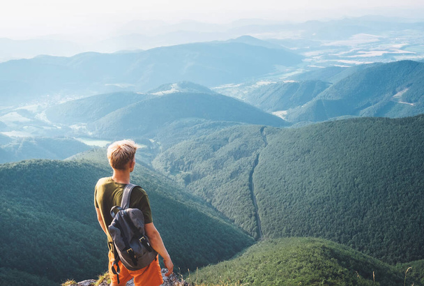 Молодий турист стоїть на вершині пагорба і насолоджується панорамою нескінченних пагорбів
 - Фото, зображення