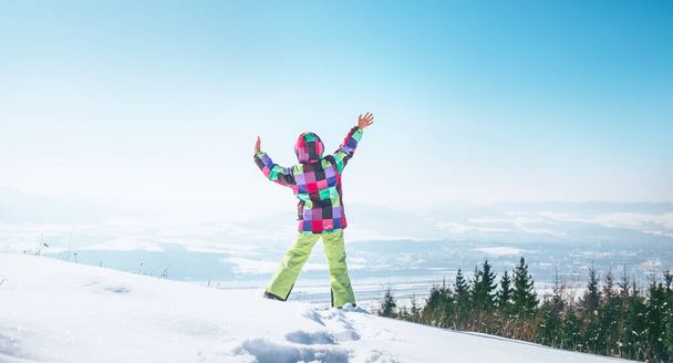 Happy little girl jumping on the snow hill - Foto, Bild