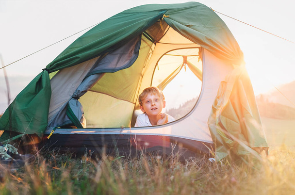 Boy rest in camping tent. Sunset time in nature - Foto, Imagem