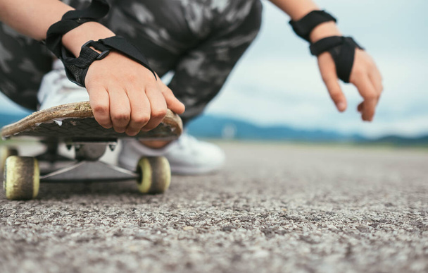 Close up image child hands holding skateboard - Photo, Image