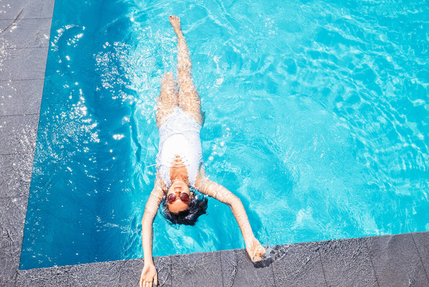 Woman relax in swiming pool on luxury resort - Фото, изображение