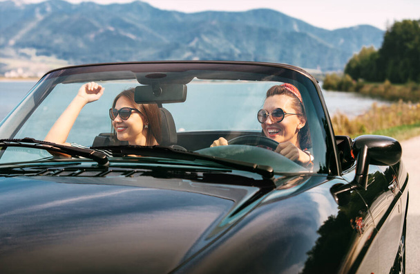 Two female friends travel in cabriolet car - Photo, image