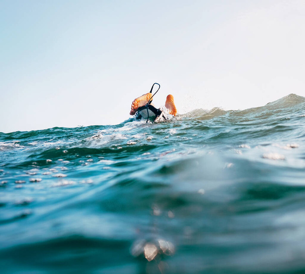 Surfer feet with safety surfboard cord on the wave crest - 写真・画像