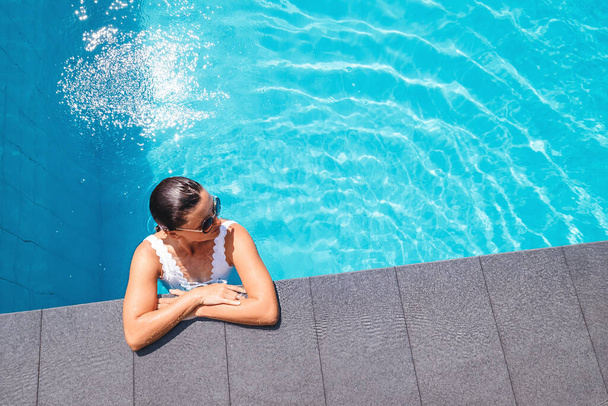 Woman relax in swimming pool - Fotoğraf, Görsel