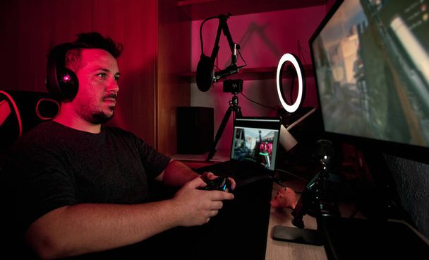 геймер, играющий и транслирующий в прямом эфире с микрофонами и камерами
 - Фото, изображение