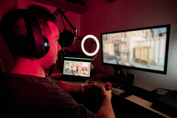 геймер, играющий и транслирующий в прямом эфире с микрофонами и камерами
 - Фото, изображение