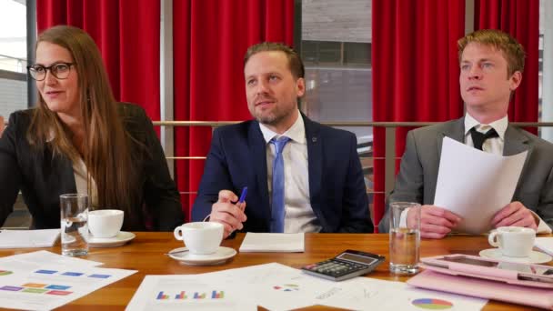 drei Geschäftspartner treffen sich im Konferenzsaal mit roten Vorhängen im Hintergrund - Filmmaterial, Video