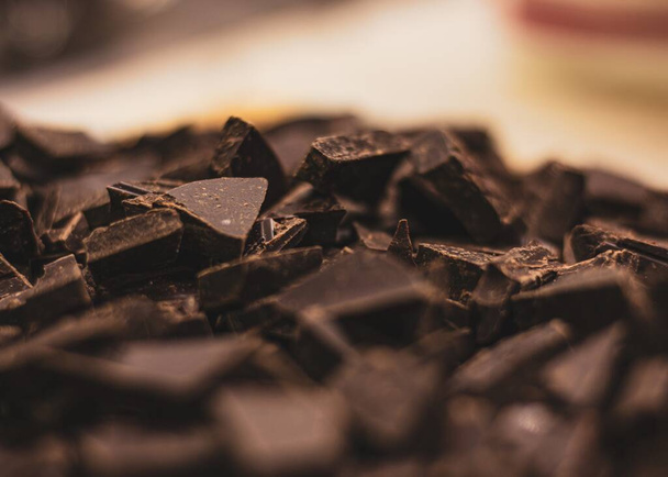 A selective focus shot of chopped dark chocolate pieces on a pile - Zdjęcie, obraz