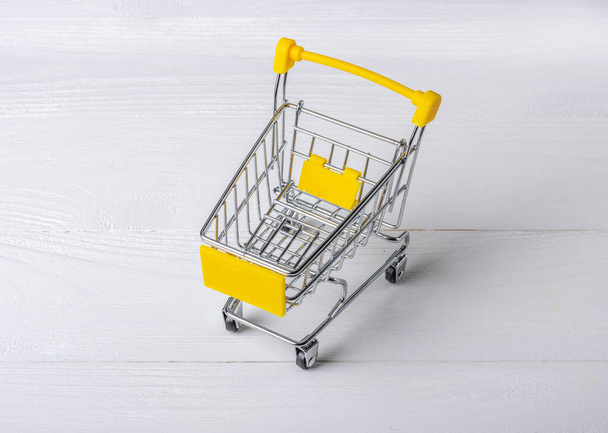 Empty shopping cart on a white wooden background - 写真・画像