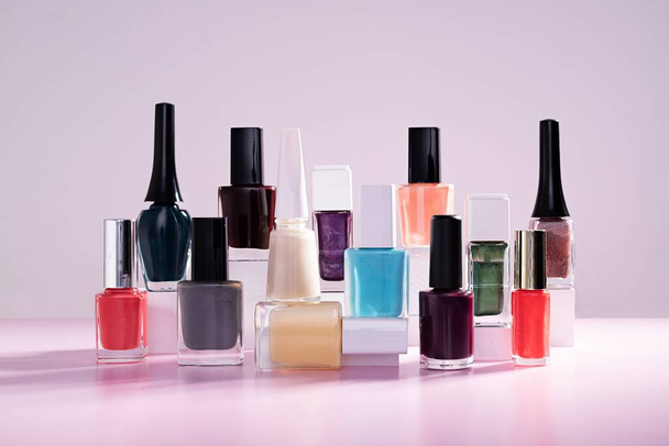 A picture of colorful nail polishes against a purple background - Fotografie, Obrázek