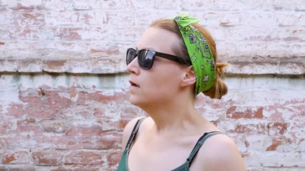 Woman with pollen allergy symptom smelling air with nose standing on brick wall background. Young sick girl sneezing, blowing her nose into handkerchief, using nasal spray against allergic rhinitis. - Footage, Video