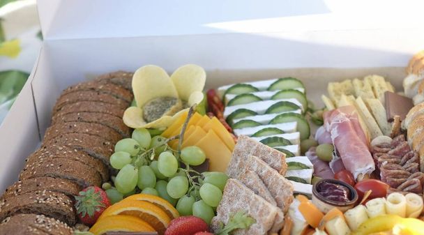 Delicious and inviting picnic box filled with a variety of finger food - Foto, Imagen