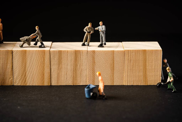 Miniature Builder Figures with wooden blocks, Labour Day Concept - Foto, Imagen