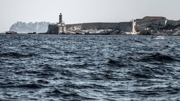 A close up shot of Chteau d'If in Marseille, France, surrounded by water and ships  - Fotó, kép