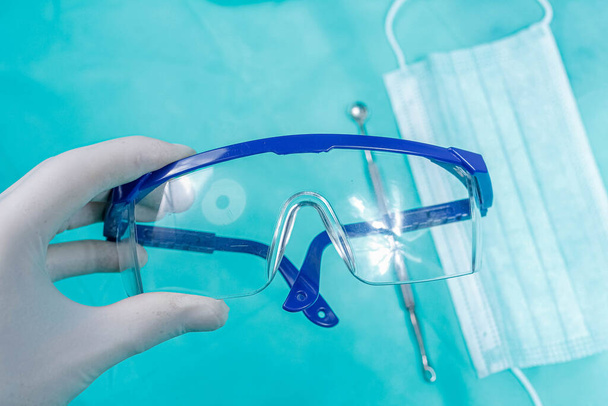 Doctor holding surgical protective modern glasses in medicine - Foto, imagen