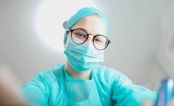 Portrait of a young doctor girl in uniform and mask. - Foto, Bild