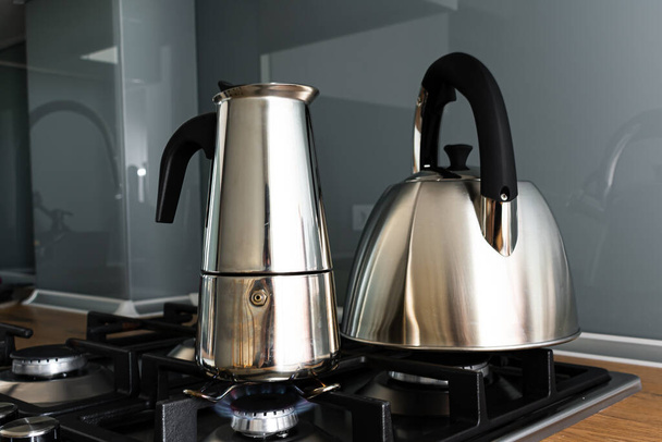close-up view of metal kettle and coffee pot on stove in kitchen - Foto, imagen