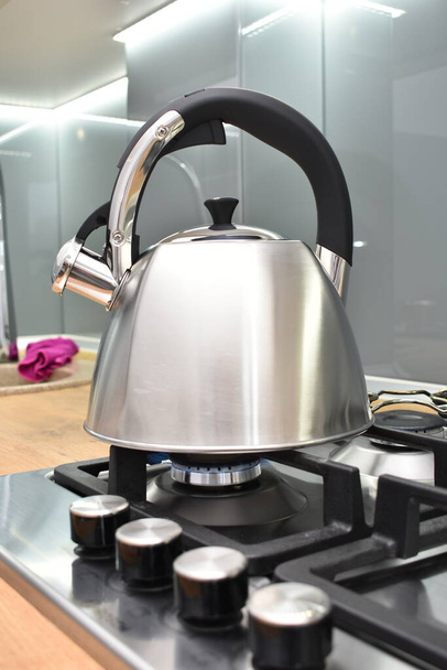 metal kettle on stove in modern kitchen - Фото, изображение