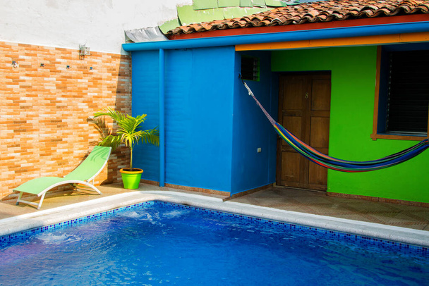 САНТА-АНА, ЭЛЬ-САЛЬВАДОР - 06 мая 2014 года: Крытый бассейн с гамаком в хостеле в Санта-Ане, Сальвадор, Центральная Америка.
 - Фото, изображение