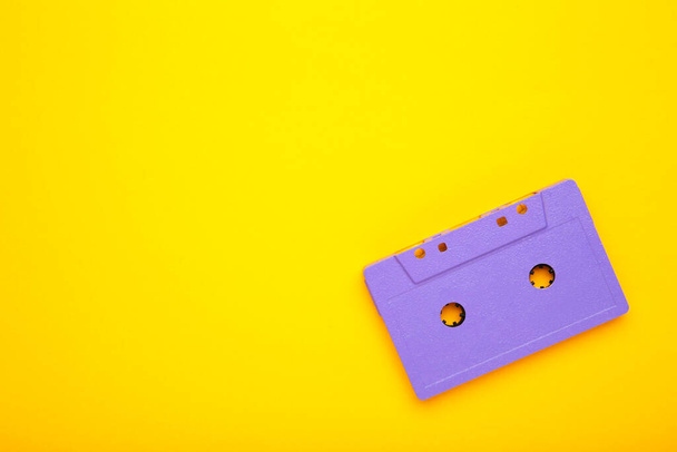 Old violet audio cassette on yellow background with copy space. Music day, top view - Fotoğraf, Görsel