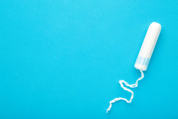 Menstrual tampon on a blue background. Cotton tampon for women. Top view - Foto, immagini