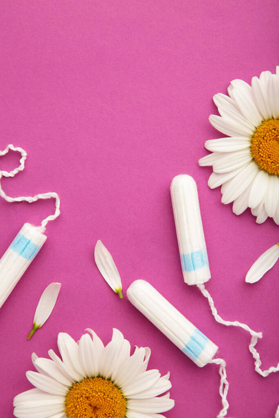 Medicinal chamomile flower and menstrual sanitary tampon. Medical conceptual photo on pink. Vertical foto - Foto, Imagem