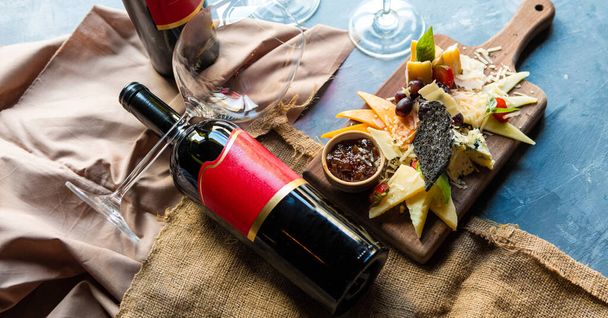 Bottiglia di vino, bicchiere con mix di formaggio, salsa. Vista dall'alto - Foto, immagini
