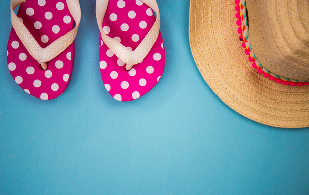 beach accessories on a blue background, beach slippers, hat, goggles. Copy space, text space. Holidays at sea - Foto, Imagen