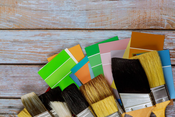 Decorador profissional várias ferramentas de pintura com uma escova e paleta de cores no fundo de madeira
 - Foto, Imagem