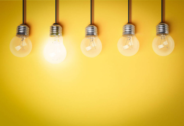 Idea concept. Light bulbs on yellow background, space for text  - Zdjęcie, obraz