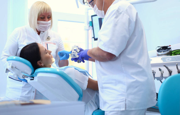 Male dentists examining and working on young female patient.Dentists office. - Foto, Imagem