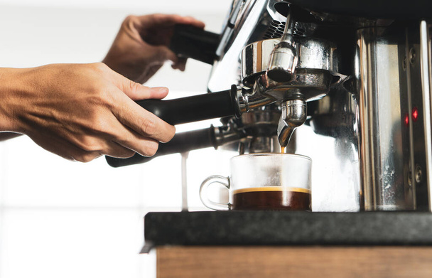 primer plano imagen de la máquina de café de la cerveza expresso en una taza en el restaurante. concepto de barista y cafetería
 - Foto, Imagen