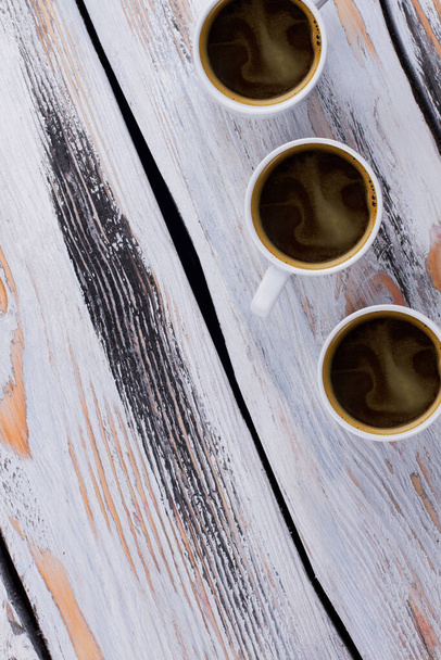 Drei Kaffeetassen auf weißem Holz. - Foto, Bild