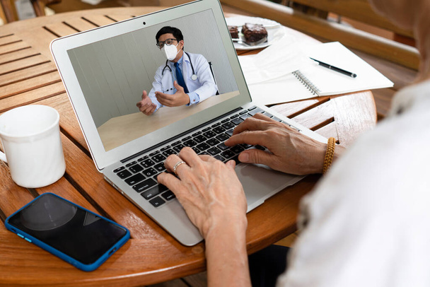 senioren Aziatische vrouw die gezondheidsproblemen heeft met behulp van computer om arts te raadplegen via videoconferentie. gezondheidszorg en medisch concept - Foto, afbeelding