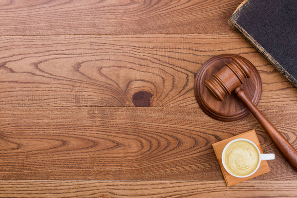 Dřevěné soudcovské kladivo a šálek kávy na dřevo. - Fotografie, Obrázek