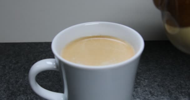 Milk jug pours milk into coffee cup - Footage, Video