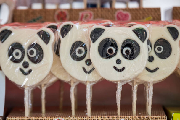 Groupe de sucettes de sucre panda en vente dans un magasin de bonbons dans un emballage en plastique individuel, mise au point sélective - Photo, image