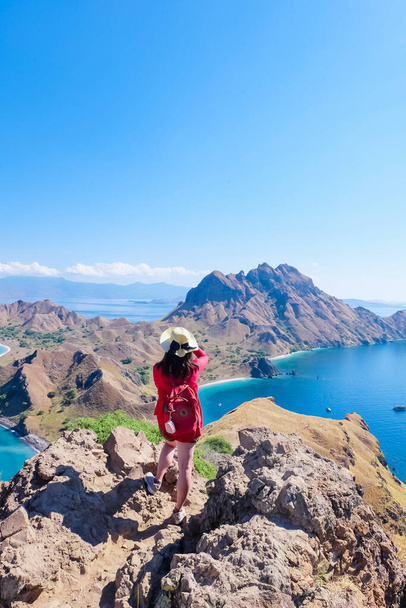 June 14, 2018 - Labuan Bajo, Komodo National Park, Indonesia : Asian girl in red cardigan taking a shot/picture on top of Padar Island - Photo, Image