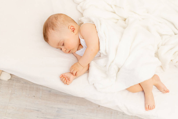 Маленькая девочка 6 месяцев спать в белой кровати, здоровый сон ребенка. - Фото, изображение