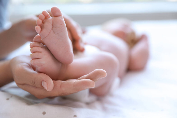Mother and her newborn baby on bed, closeup. Space for text - Foto, afbeelding