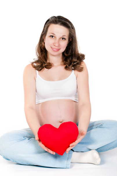 jonge zwangere vrouw op een witte achtergrond - Foto, afbeelding